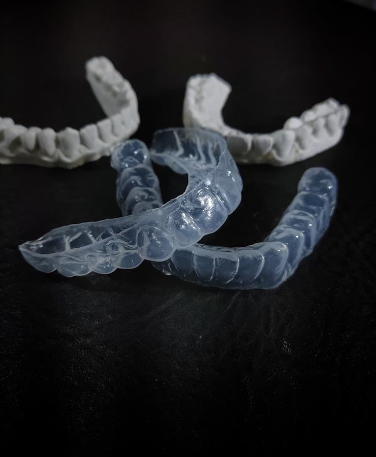 Modelos de dispositivos odontológicos sobre uma superfície escura.